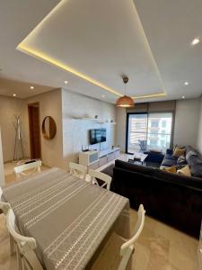 a living room with a couch and a table at Pearl Chic Stay Pool and View in Rabat