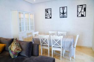 a living room with a table and chairs and a couch at Pearl Chic Stay Pool and View in Rabat
