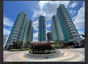 three tall apartment buildings with a park in front at H2G Mesavirre Garden Residence in Bacolod