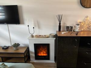a living room with a fireplace and a television at Inkognito in Teplice