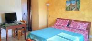 Un dormitorio con una cama y un escritorio con una computadora. en Apartament di Nick Central Station, en Palermo