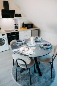 a dining room table with chairs and plates on it at Sewwa Guest House in Sélestat +4 photos