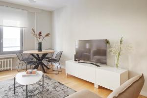 サン・セバスティアンにあるArrasate 2 by FeelFree Rentalsの大きなテレビとテーブルのあるリビングルーム