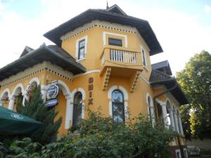 een geel huis met een balkon erboven bij Pensiunea Onix in Făgăraş
