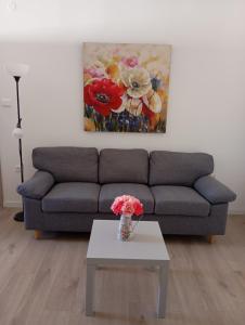 ein Wohnzimmer mit einem Sofa und einem Tisch mit Blumen in der Unterkunft House Daniela in Omišalj