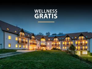 un grande edificio con le parole wellnessaris illuminato di notte di Pytloun Wellness Hotel Hasištejn a Místo