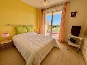 a bedroom with a bed and a window and a television at Quiberon : Appartement 2P avec Terrasse et Animaux Acceptés - FR-1-478-32 in Quiberon