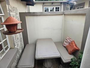 eine Bank auf einem Balkon mit einer Lampe und einem Kissen in der Unterkunft Melville Guesthouse & Contractors Lodge in Lichtenburg