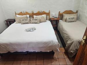 zwei Betten in einem Zimmer mit zwei Betten sidx sidx sidx in der Unterkunft Melville Guesthouse & Contractors Lodge in Lichtenburg
