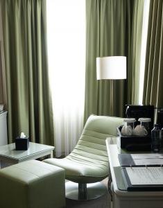 a living room with a couch and a chair and a table at Hotel London 1889 & Casino in Batumi