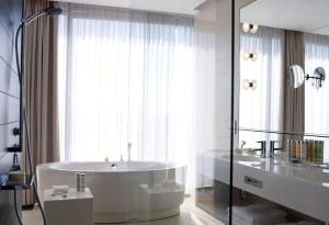 a white bathroom with a tub and a sink at Radisson Blu Resort & Spa in Split