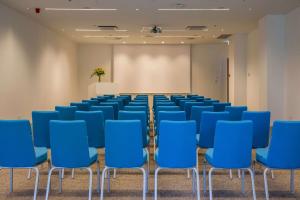 an empty room with blue chairs and a screen at Radisson Blu Resort & Spa in Split