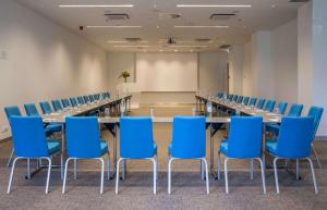 a conference room with a long table and blue chairs at Radisson Blu Resort & Spa in Split