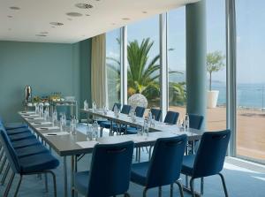 a room with a long table and blue chairs at Radisson Blu Resort & Spa in Split