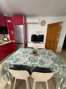 a kitchen with a table and chairs and a kitchen with red cabinets at lujo a 50 metros de la playa in Rincón de la Victoria