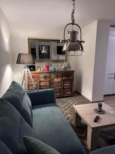 Una sala de estar con un sofá azul y una mesa. en Luxury-Wellnessresidence- Altes Kapitänshaus, en Dranske