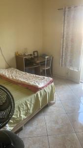 a bedroom with a desk and a table and a bed at Condomínio azul in Paraty