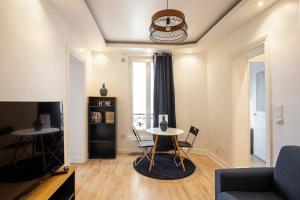 a living room with a table and a couch at Luxury apartment saint mande 5 minuts from Paris in Saint-Mandé