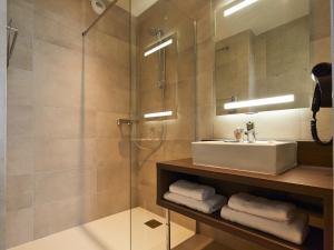 a bathroom with a sink and a glass shower at Kyriad Troyes Centre in Troyes +42 photos