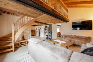 a living room with a couch and a staircase at EcoLoft, Parking, bubble bath, views, tranquility in Eischoll