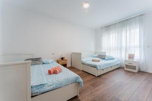 ein Schlafzimmer mit zwei Betten und einem Fenster in der Unterkunft Flex SelfCheckIns 100 - Zagreb - 2 Bedrooms - Parking - Loggia in Velika Mlaka
