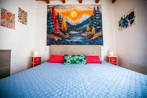 a bedroom with a bed and a painting on the wall at Il Borghetto in Lanzo dʼIntelvi