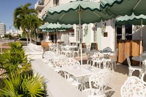 a group of tables and chairs with an umbrella at FOUND Hotel Miami Beach in Miami Beach