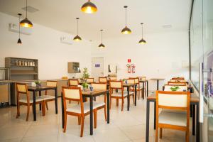 a restaurant with tables and chairs in a room at EL SHADDAI HOTEL in João Pessoa