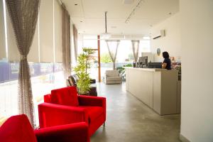 an office with red chairs and a woman at a counter at EL SHADDAI HOTEL in João Pessoa