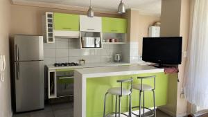 a kitchen with green and white cabinets and stools at Condominio Nova Pacifico in La Serena