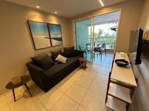 una sala de estar con un sofá y una mesa en Porto Beach Conforto e Lazer a 200m do B Park, en Aquiraz