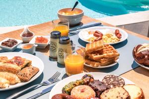 a table topped with plates of breakfast foods and drinks at La Isola Verde in Skala Potamias
