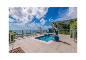 a swimming pool on a balcony with the ocean in the background at A Fantastic apart with balcony and partial view of the beach 4 Px in Hollywood