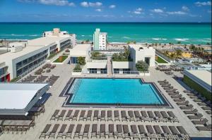an aerial view of a resort with a swimming pool and the ocean at A Fantastic apart with balcony and partial view of the beach 4 Px in Hollywood