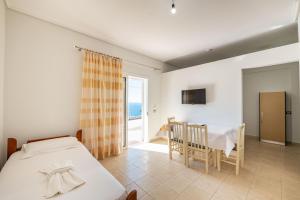 a bedroom with a bed and a dining room with a table at Vila Celi in Sarandë