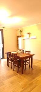 a dining room with a wooden table and chairs at Martina house Fiumicino in Isola Sacra +5 photos