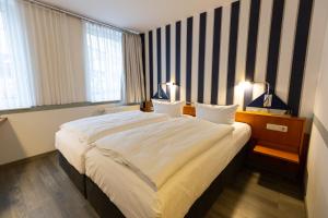 a hotel room with a large bed in a room at Hotel DH VEC in Vechta