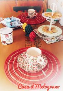 a table topped with red and white plates and cups at Casetta il Melograno Cozy two-room apartment to the Sea in Villaggio Mosè