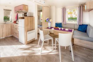 kuchnia i salon ze stołem i krzesłami w obiekcie Camping Baciccia w mieście Ceriale