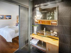 a bathroom with a sink and a bed in a room at Chalet de Rollon - OVO Network in Thônes +17 photos