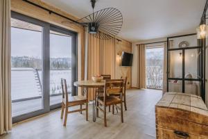a dining room with a table and chairs and windows at Tatra Panorama Residence - Ski, Hike & Relax Retreat in Zakopane