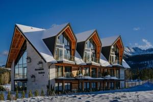 a large house with a snow covered roof at Tatra Panorama Residence - Ski, Hike & Relax Retreat in Zakopane