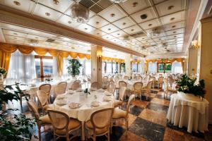 a banquet hall with white tables and chairs at Hotel Conca d'Oro in Salò