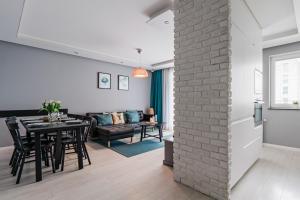 uma sala de jantar e sala de estar com uma parede de tijolos em Apartament Aurora, Free parking em Gdańsk