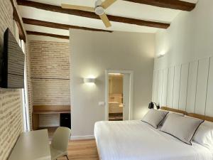 a bedroom with a bed and a table and a chair at Cosy Rooms Embajador in Valencia