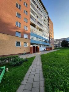 ein Backsteingebäude mit einem Bürgersteig neben einer Wiese in der Unterkunft Cozy Baltic Nest in Klaipėda