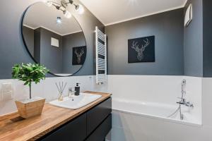 um banheiro com uma pia e um espelho em Apartament Aurora, Free parking em Gdańsk mais 13 fotografias