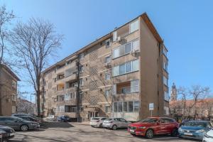 un immeuble d'appartements avec des voitures garées dans un parking dans l'établissement Snagov Flat, à Oradea
