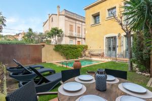 a patio with a table and chairs and a pool at Oasis en el centro de Palafrugell in Palafrugell
