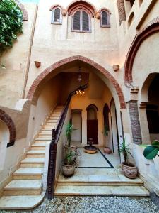 una entrada a un edificio con escaleras y plantas en Villa Rosamund, en Luxor 20 fotos más